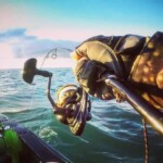 Softbait rod under load during kayak hookup in open saltwater