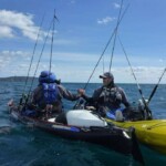 Two kayak anglers on open water with softbait fishing setups in New Zealand