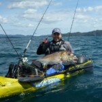 Angler holding a large snapper from a compact offshore fishing setup in New Zealand coastal water